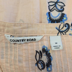 Close-up of a shirt with floral patterns and 'Country Road' label.