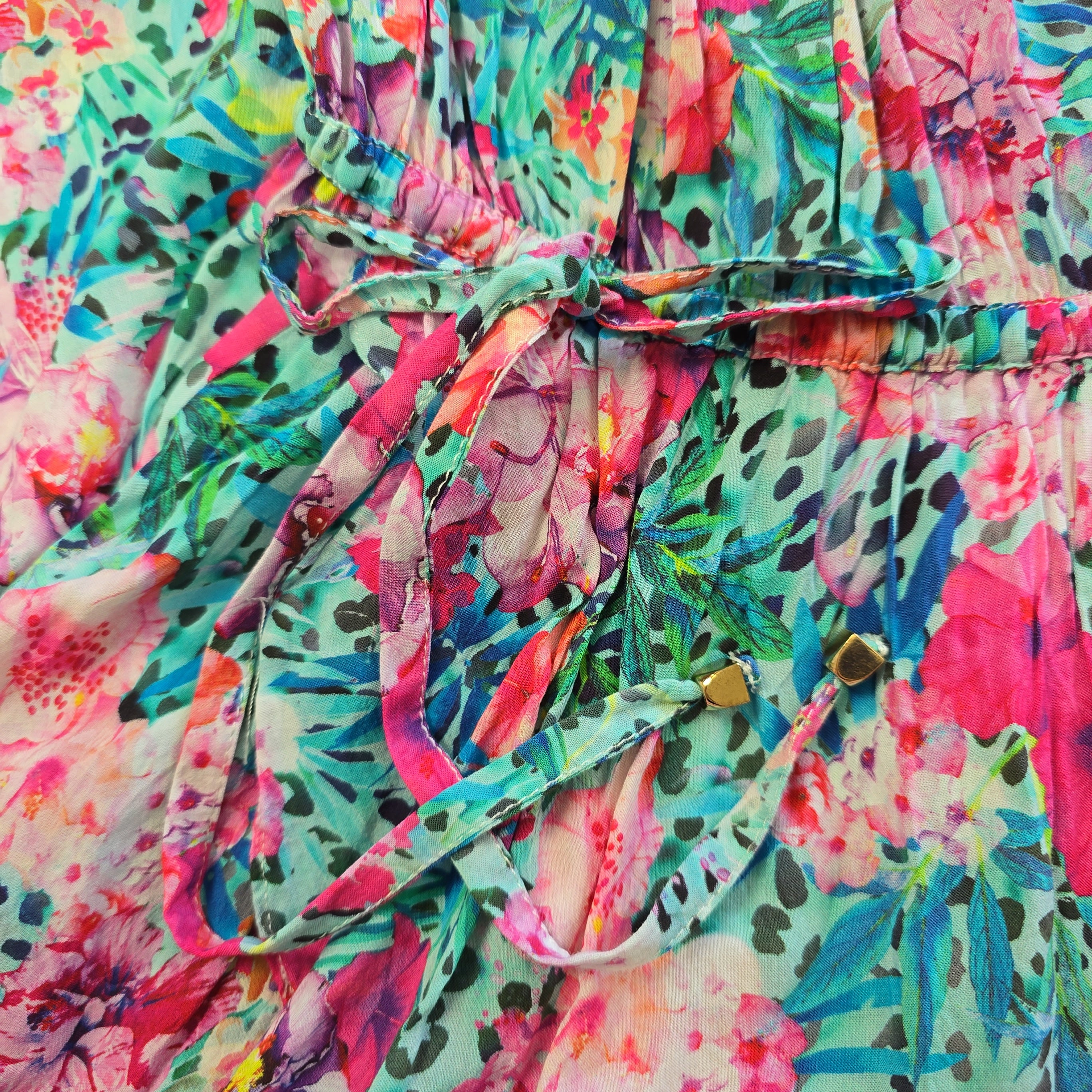 Close-up of a colorful floral and animal print fabric with gold beads.