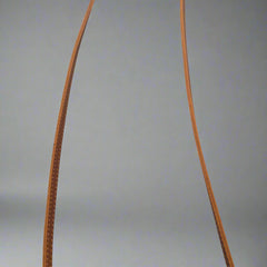 Two brown leather straps on a tiled floor