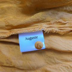 Close-up of a beige fabric with an 'Auguste' label.