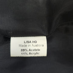 Close-up of a label on black fabric with 'Lisa Ho' branding.