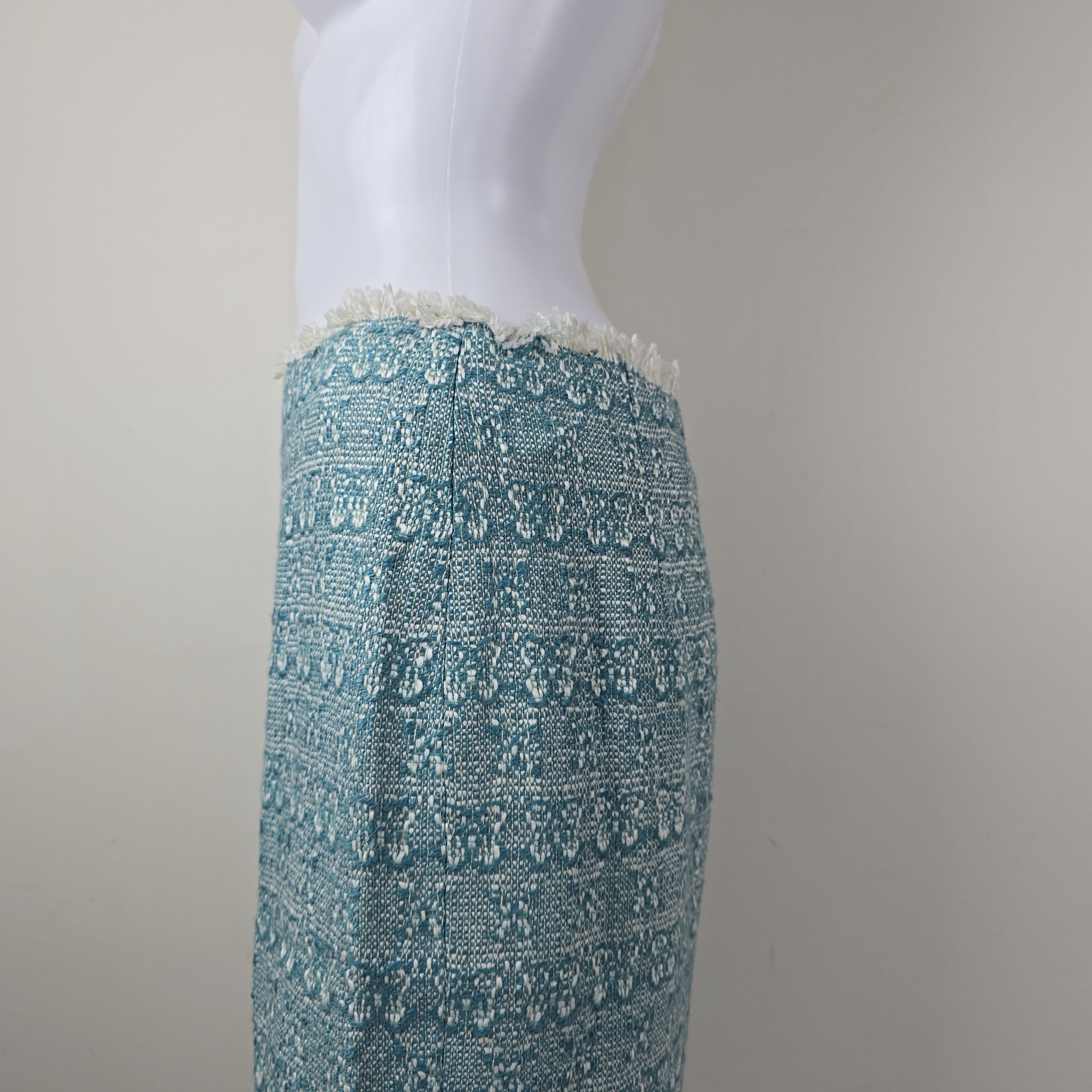Teal textured skirt on a light gray surface with a neutral background