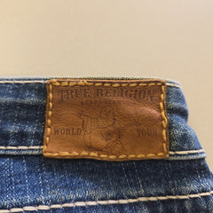 Close-up of a leather label on blue denim fabric with a beige background