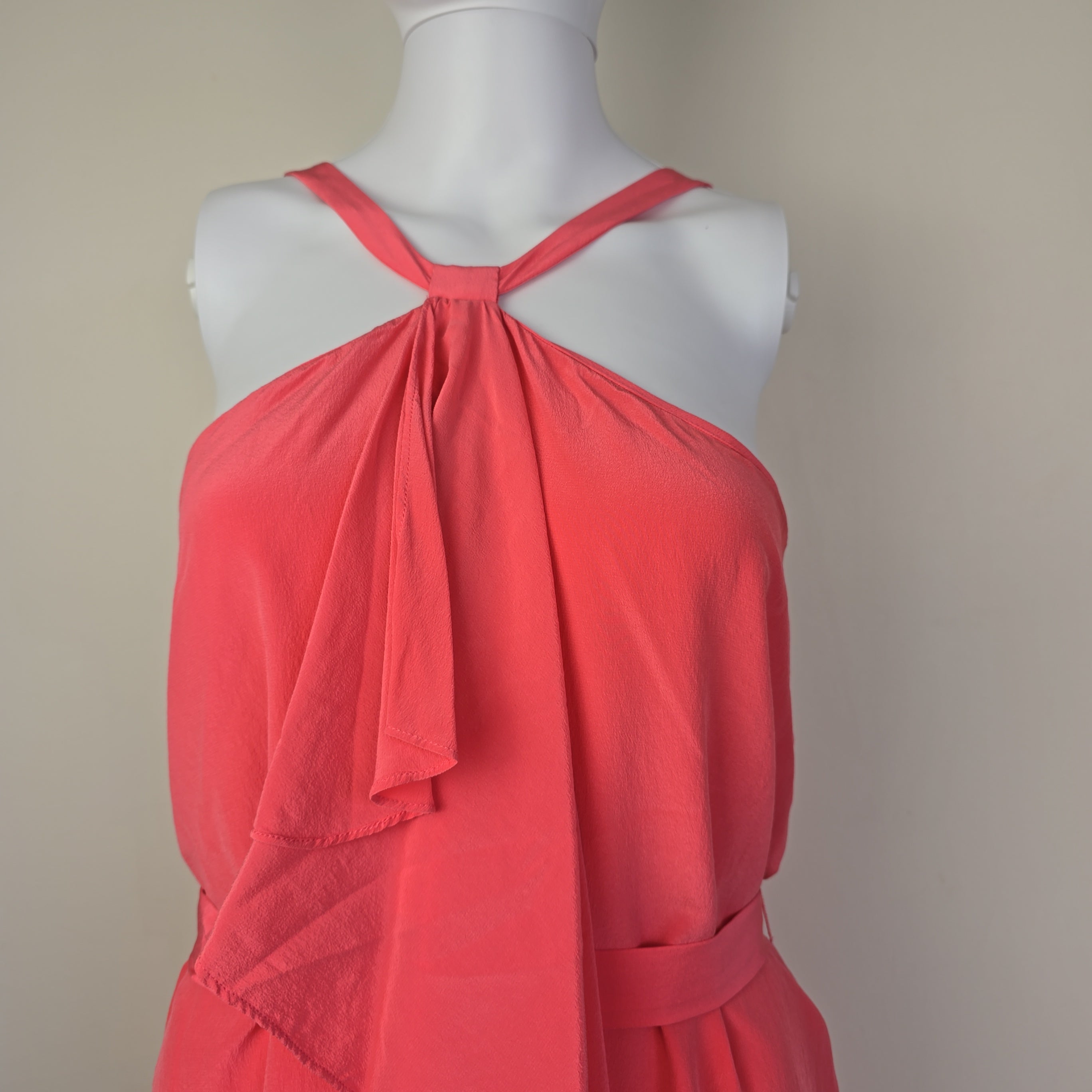 Pink dress on a mannequin against a plain background