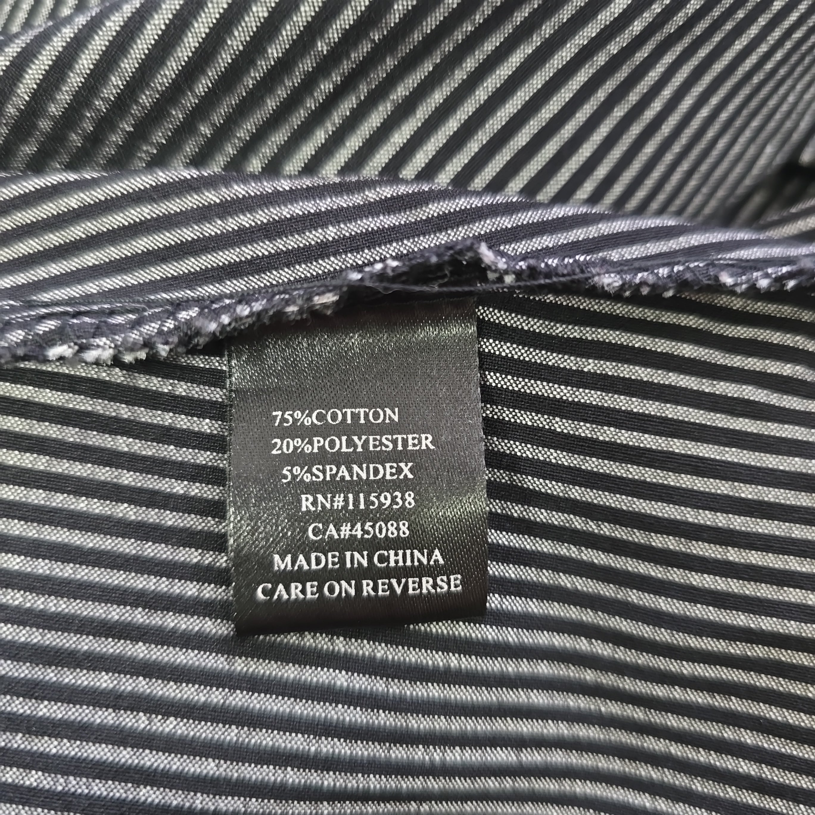 Close-up of a label on a striped fabric garment with text details.