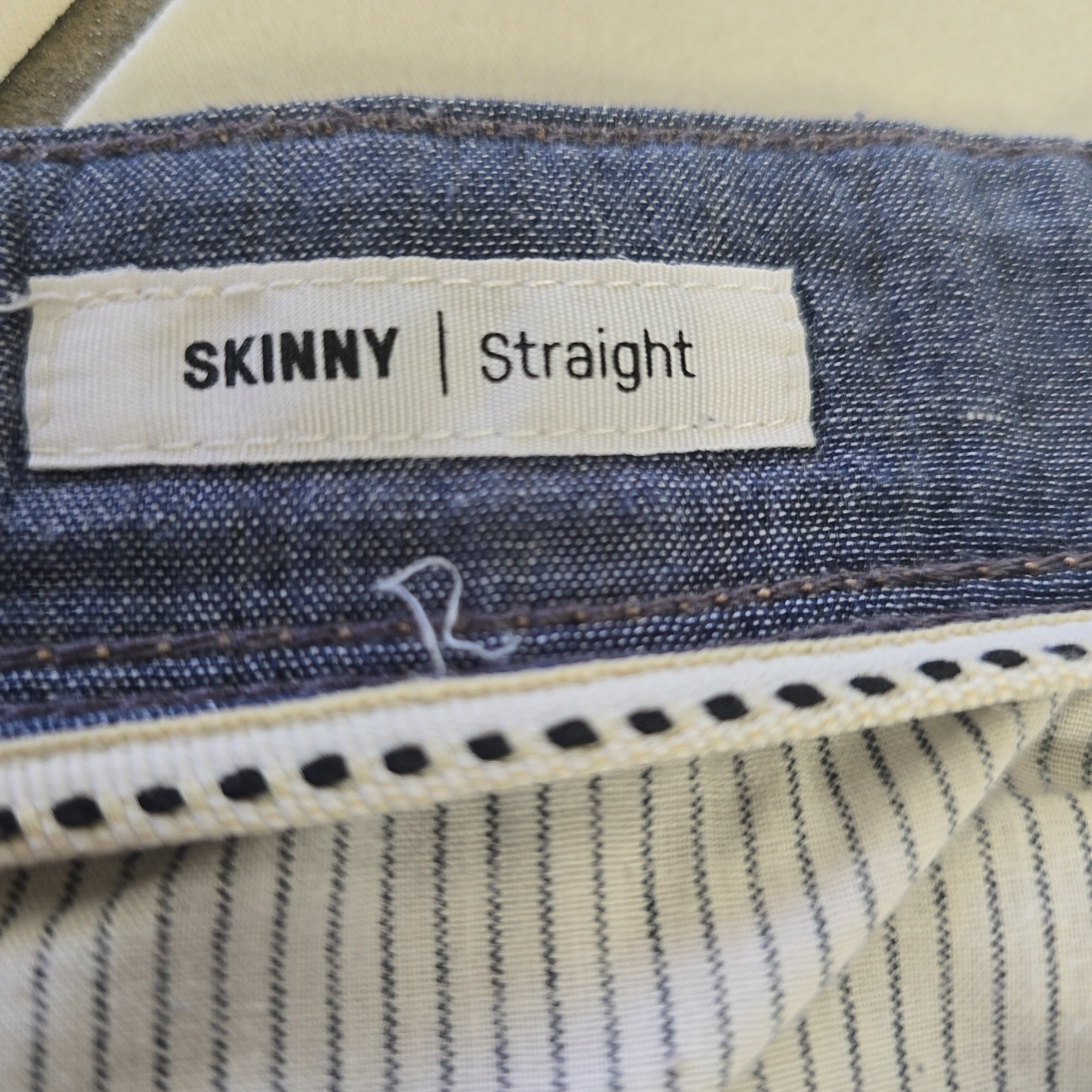 Close-up of a label on a pair of jeans indicating 'Skinny Straight' fit.