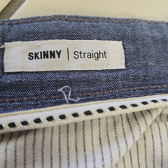 Close-up of a label on a pair of jeans indicating 'Skinny Straight' fit.