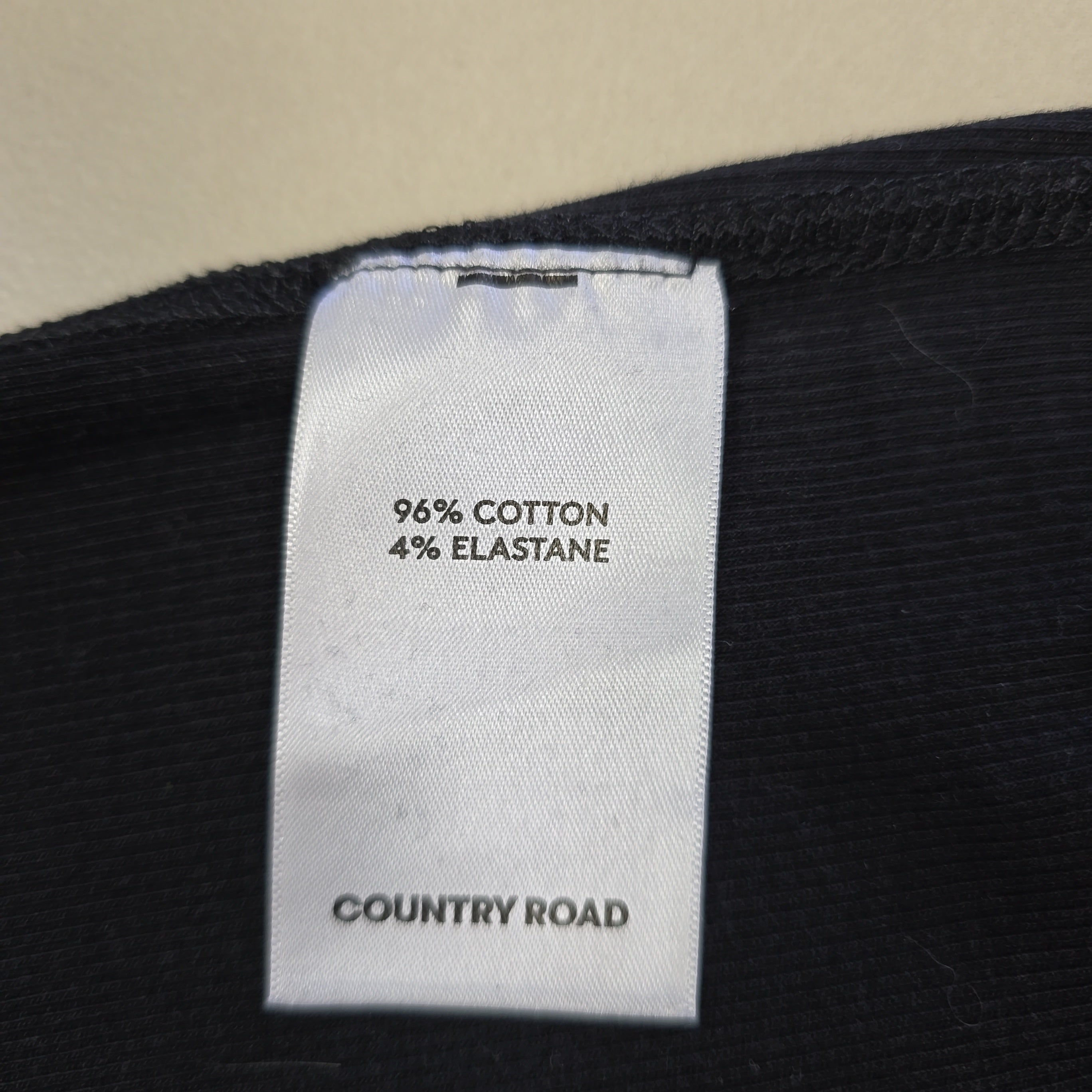 Clothing label with material information on a black fabric background