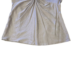 Beige top with a knot detail on alight floor