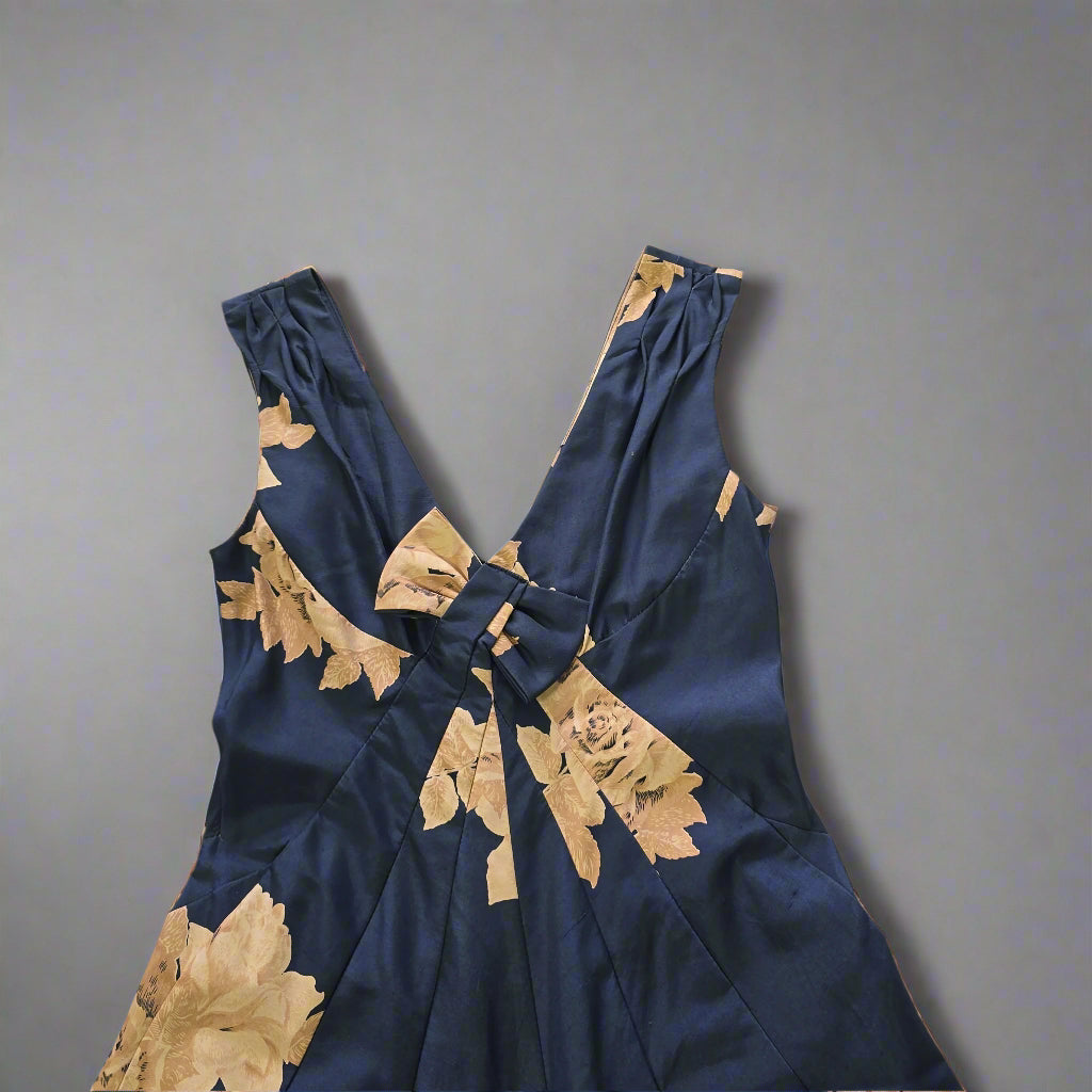 Blue dress with floral patterns on a tiled floor.