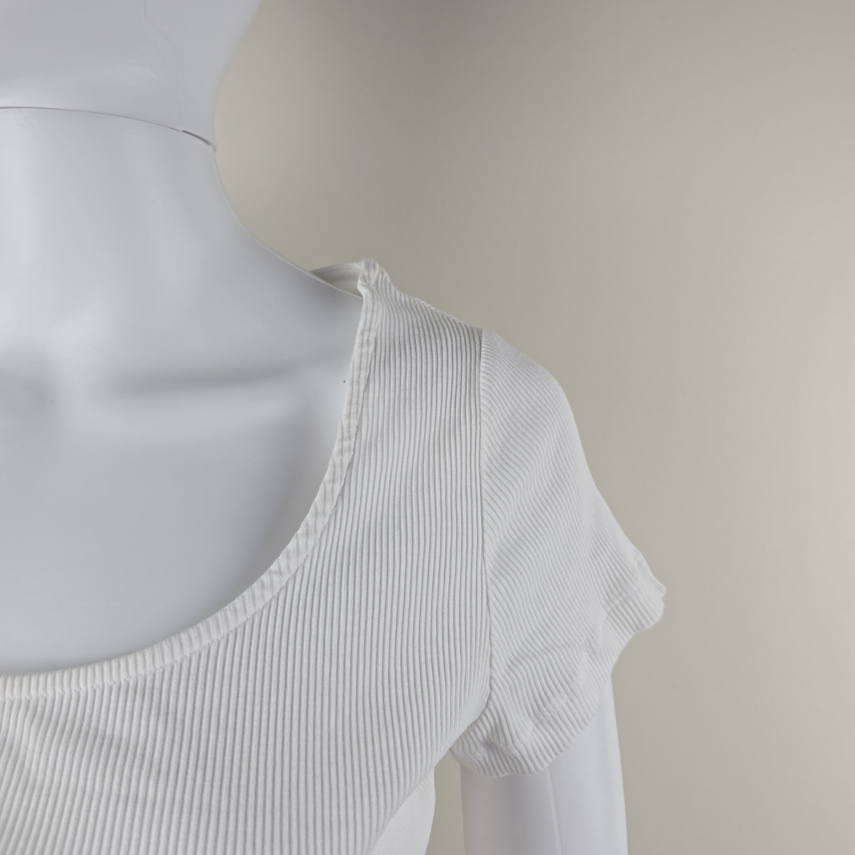 White ribbed tank top on a mannequin against a neutral background