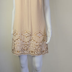 Beige lace trim on a white dress with a neutral background