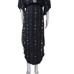 Black dress with pink floral pattern against a beige wall.