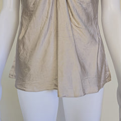 Beige top with a knot detail on alight floor