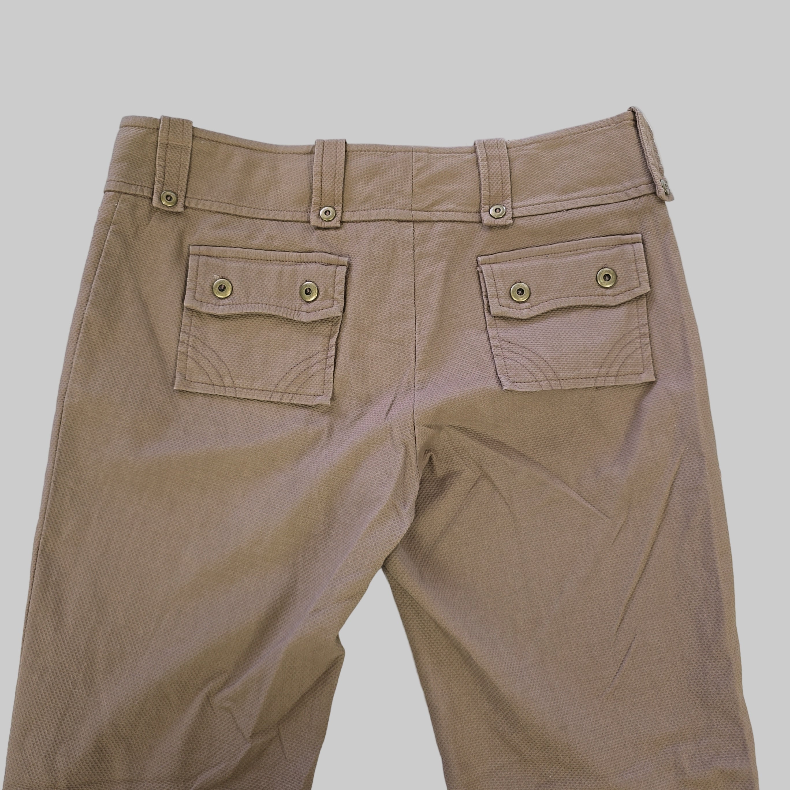 Brown pants with button details on a light gray background