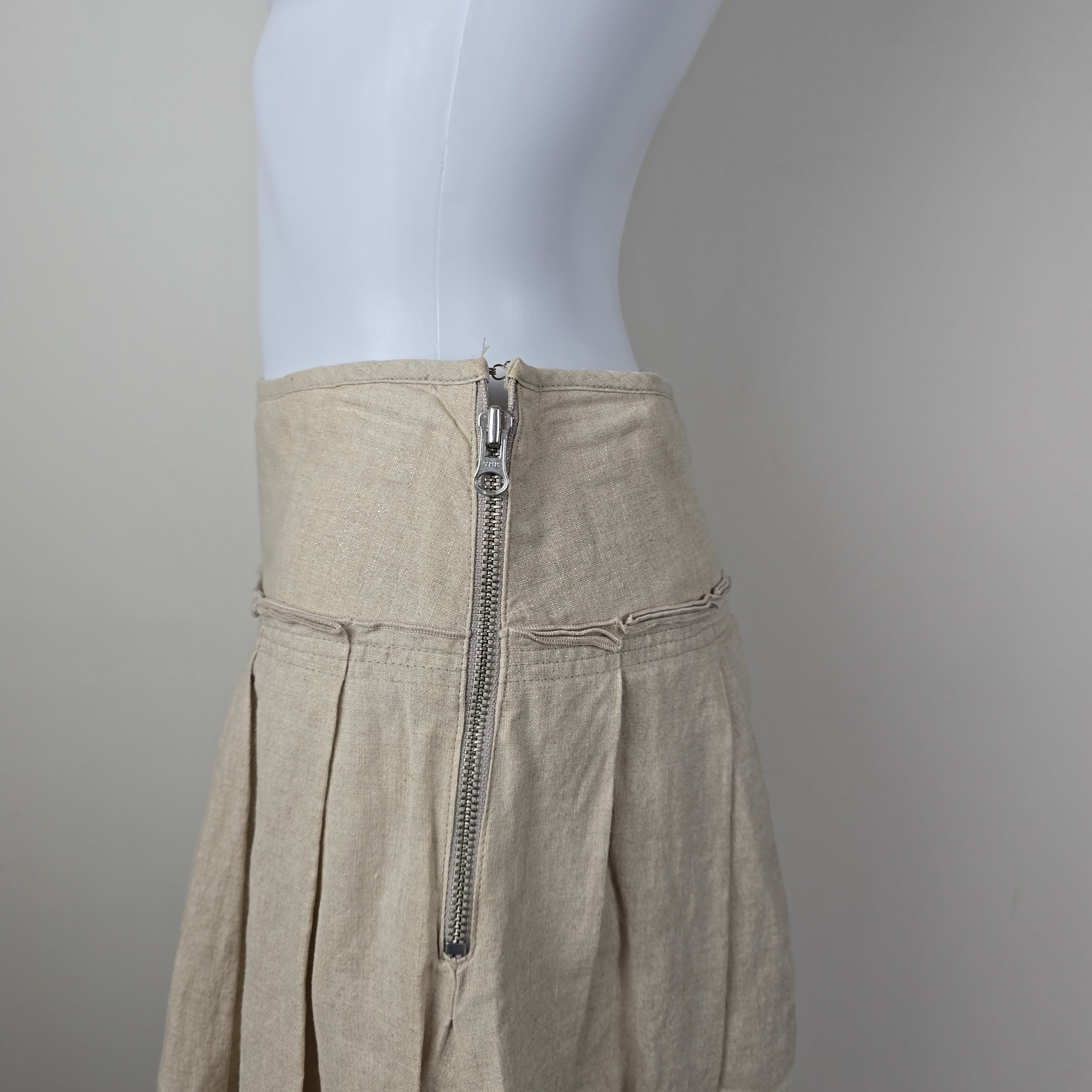 Close-up of beige skirt with a zipper on a neutral background