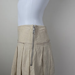 Close-up of beige skirt with a zipper on a neutral background