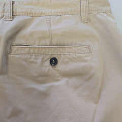 Close-up of beige pants with a button on a white background