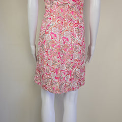 Roll of pink and white patterned fabric on a beige background