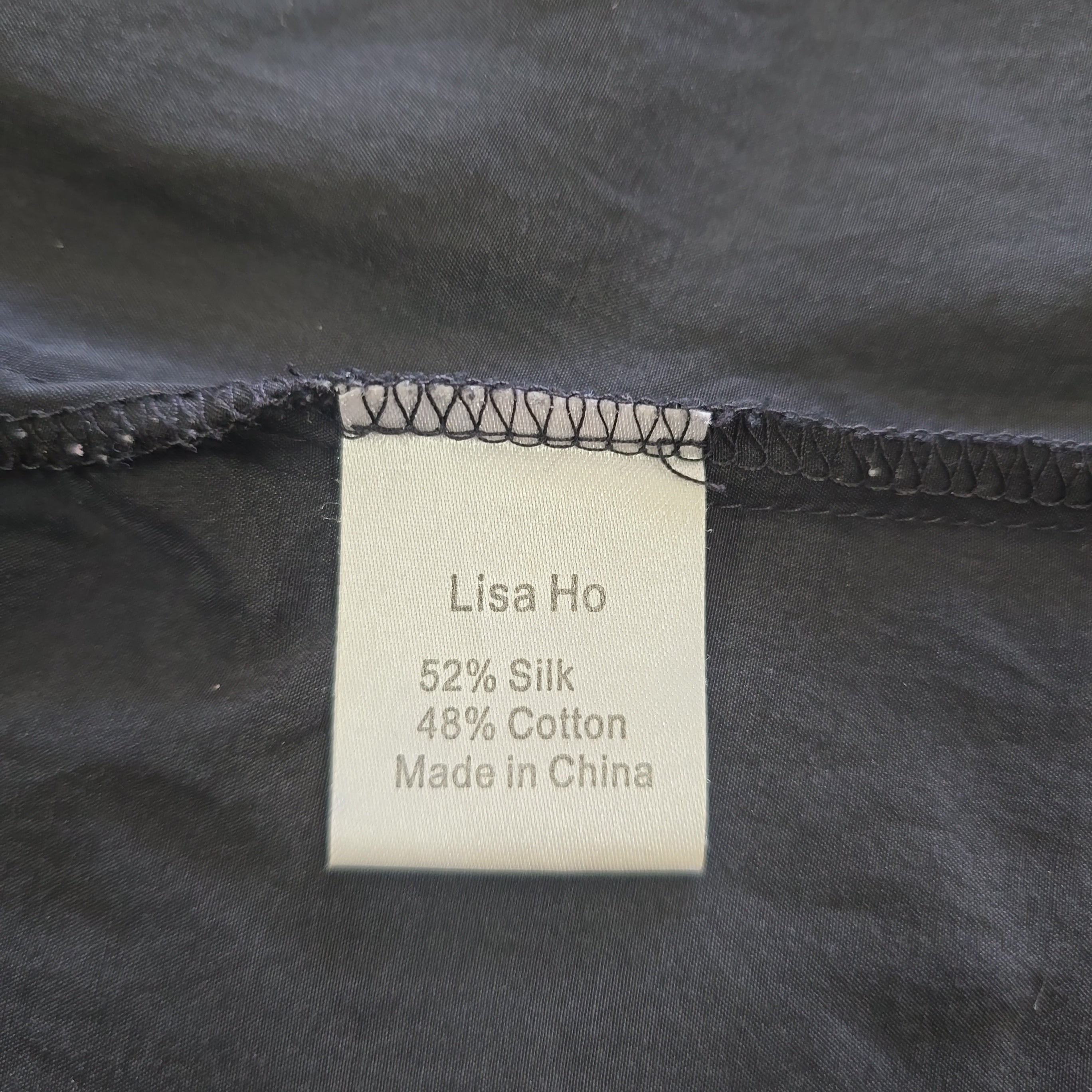 Label on a black fabric with 'Lisa Ho' branding and material details.