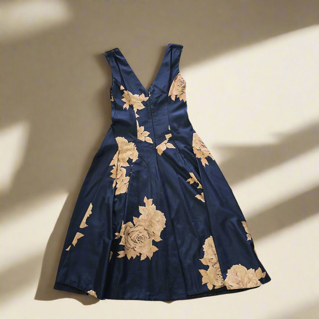 Navy blue dress with gold floral embroidery on a tiled floor.