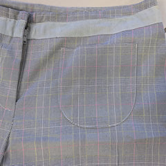 Gray plaid fabric with a pocket and zipper detail on a light gray background