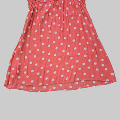 Pink dress with white polka dots on a tiled floor