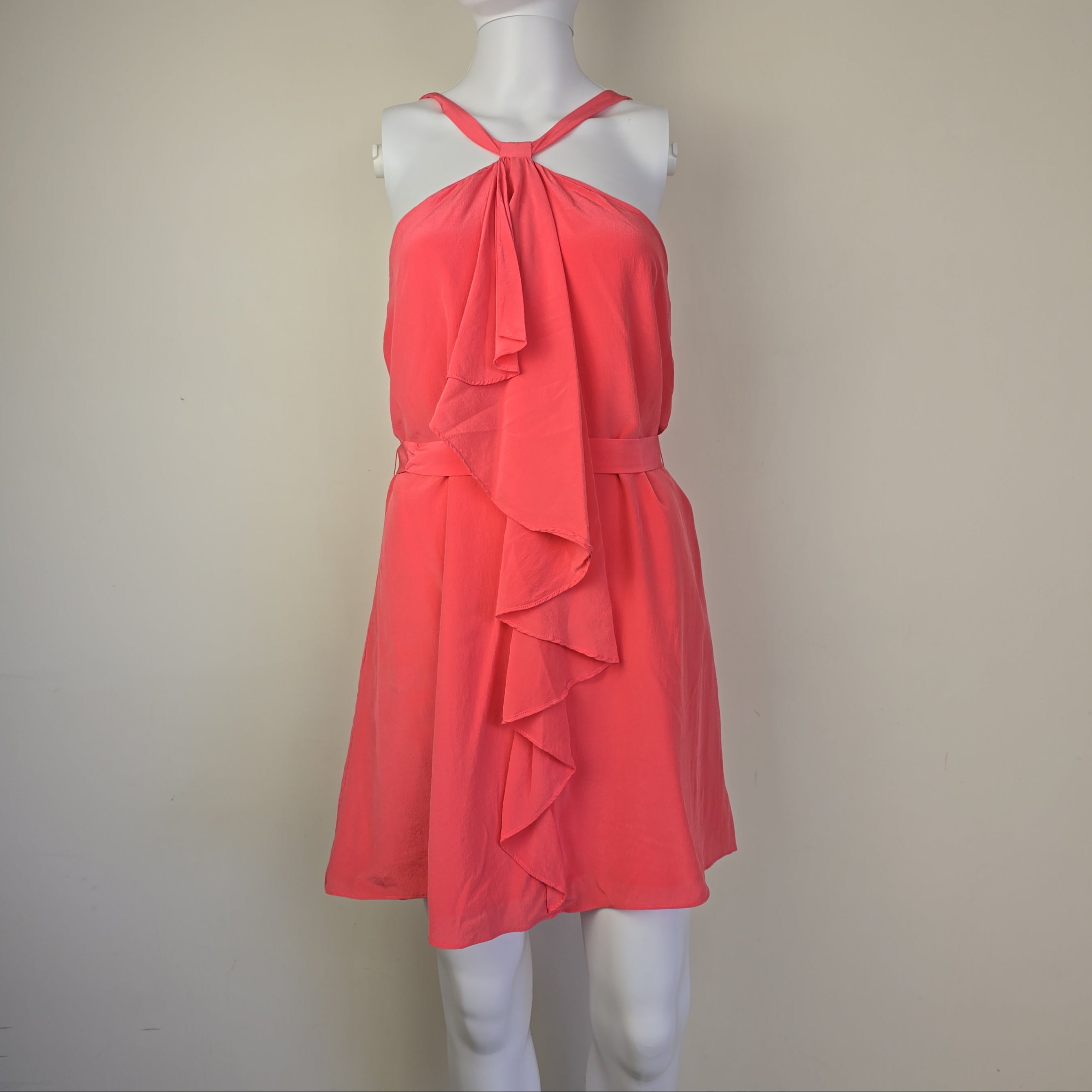 Red dress on a mannequin against a plain background