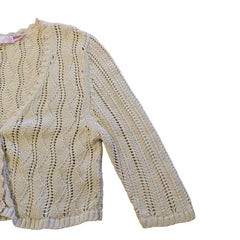 Knitted beige garment on a tiled floor