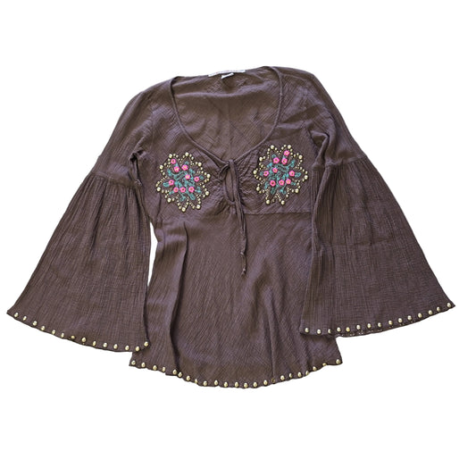 Brown garment with floral embroidery  and gold studs on a light background 2736