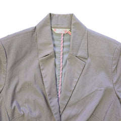 Brown jacket with pink and white striped trim on a light surface