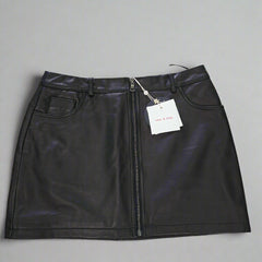 Black leather skirt with a tag on a tiled floor