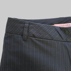Dark gray pants with a pink tag on a light beige surface