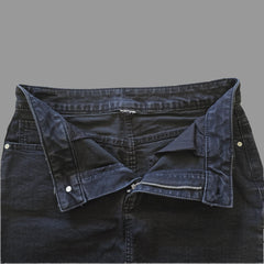 Dark grey denim skirt on a light beige surface