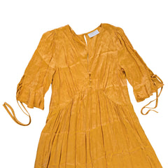 Yellow dress on a light background with a visible tag.