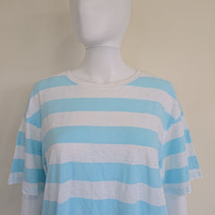 Mannequin wearing a blue and white striped top on a beige background