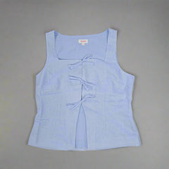 Light blue sleeveless top on a tiled floor