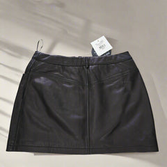 Black leather skirt with a tag on a tiled floor