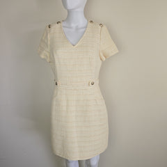 Beige dress on a mannequin against a plain background