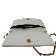 White handbag with gold chain and clasp on a light background