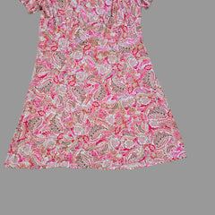 Pink and white patterned fabric on a tiled floor