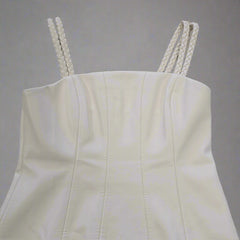 White strapless top with braided straps on a tiled floor