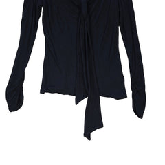 Black top with tie detail on a light background