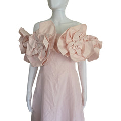 Mannequin wearing a light pink dress with floral details on a plain background