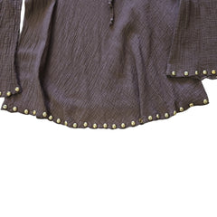Brown garment with floral embroidery  and gold studs on a light background