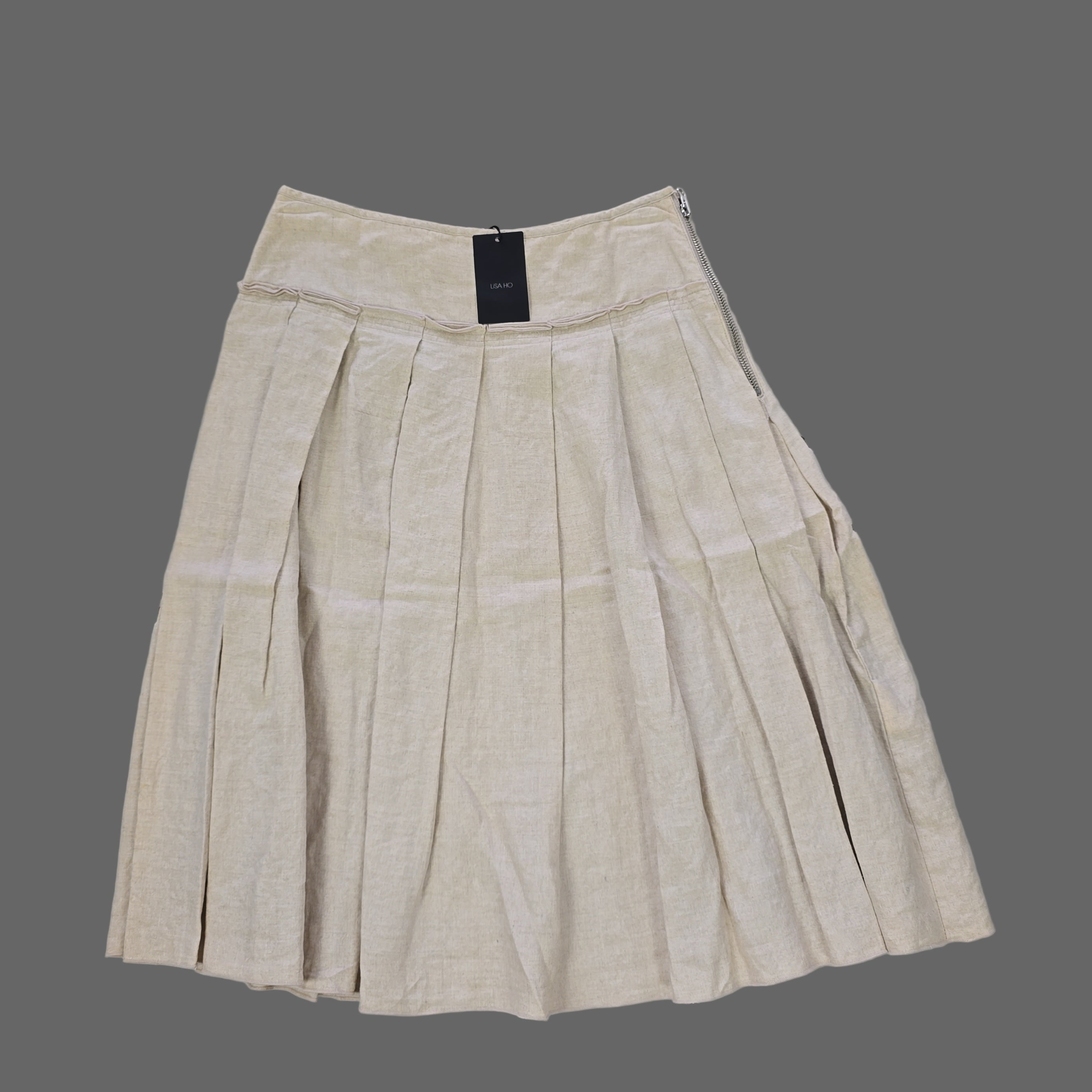 Beige pleated skirt on a tiled floor