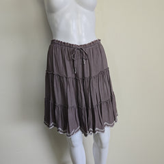 Brown pleated skirt on a mannequin against a plain background