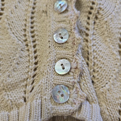 Close-up of a beige knitted fabric with button details
