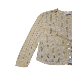 Beige lace garment with buttons on a tiled floor