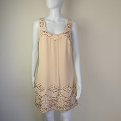 Beige dress with lace details on a mannequin against a plain background